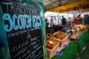 A blackboard at a farmers' market reads 'Traditional Scotch Eggs".