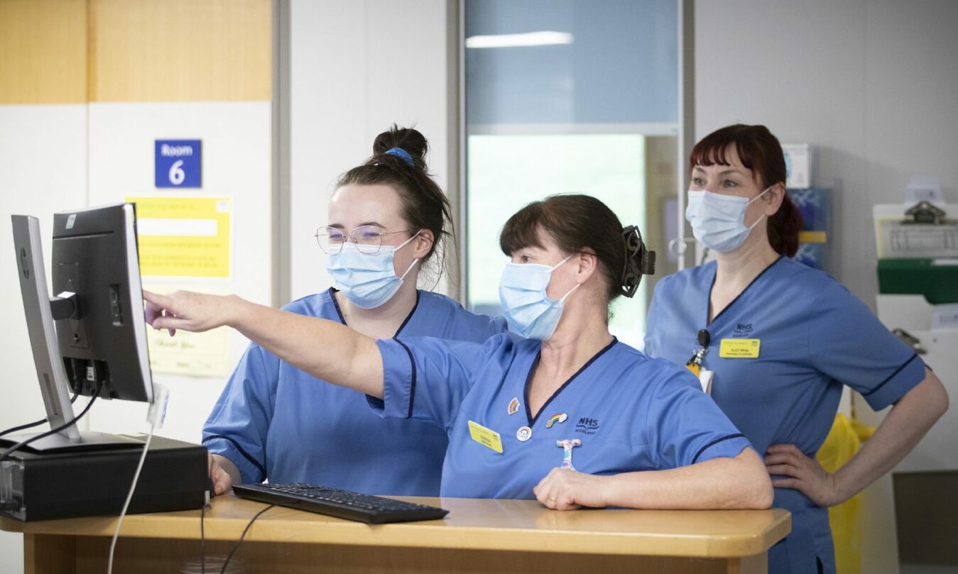 Nurses pointing at a computer screen. NHS Grampian says Christmas levels of services will likely be running during any nursing strikes.