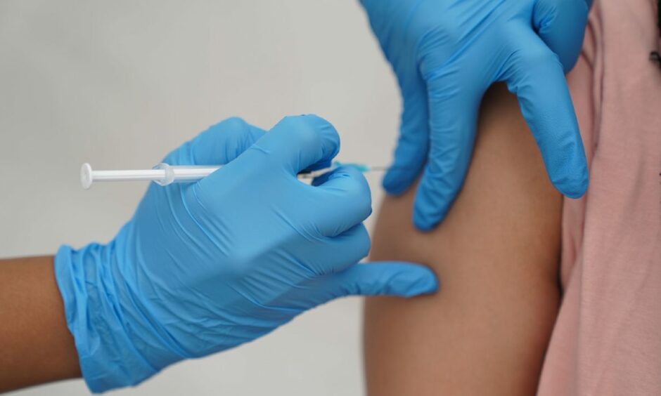 Person receiving a jab as Covid cases rise.