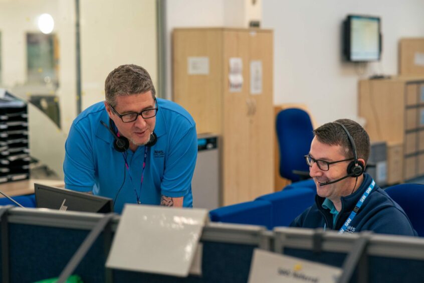 Two NHS 24 staff members answering the 111 phone lines.