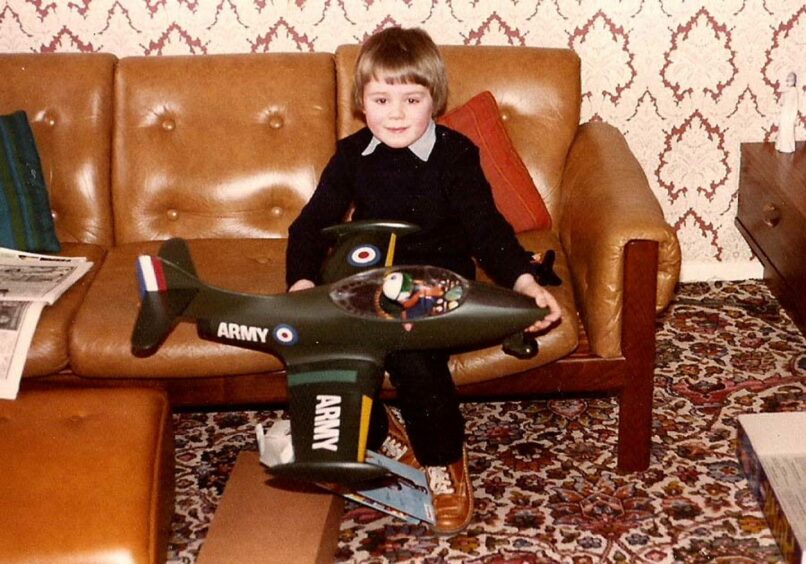 John as a young boy on the sofa with a model plane on his lap