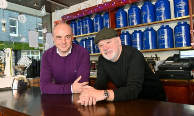 Ian and the new owner leaning against the counter in MacBeans in Aberdeen