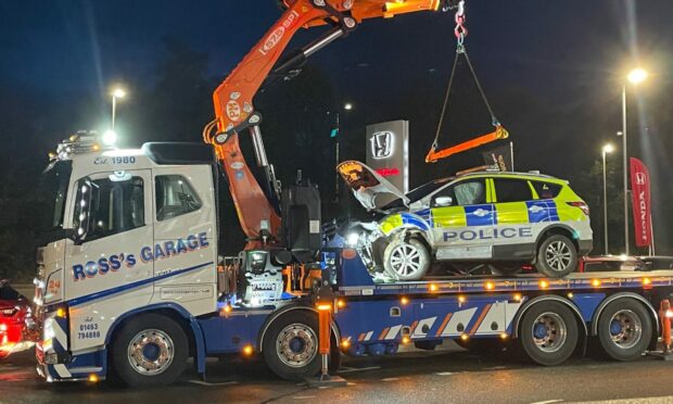 The police car was lifted from the scene by crane. Photo: Ross Hempseed/DC Thomson
