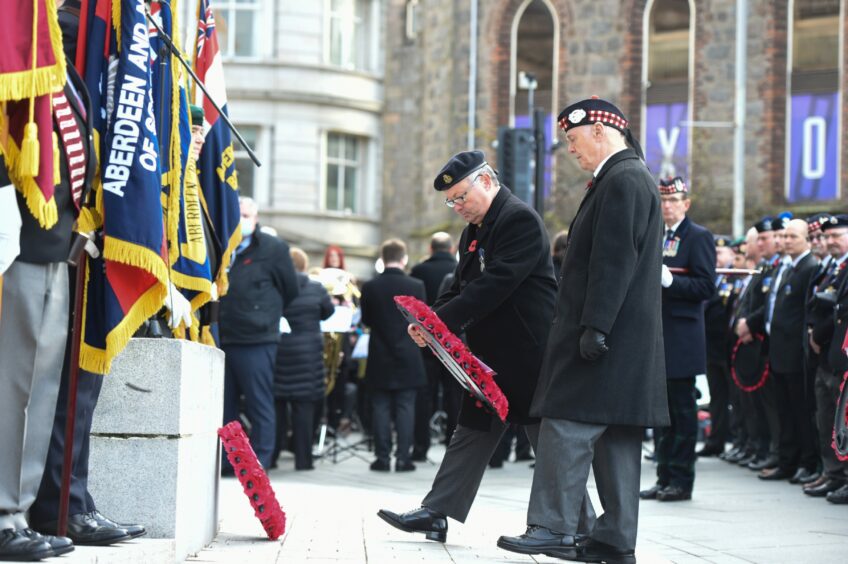 Ex-soldiers pay their respects by laying wreaths at a remembrance day event in Aberdeen 2021