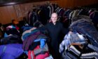 Reverend Terry Taggart with the jackets and clothing they have received. Image: Darrell Benns / DC Thomson.