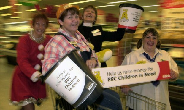 ASDA workers rush around the store holding a sign and donation bucket