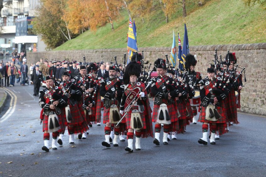 The Parade band marching in their kilts and uniforms during an Inverness Remembrance Day parade event in 2019