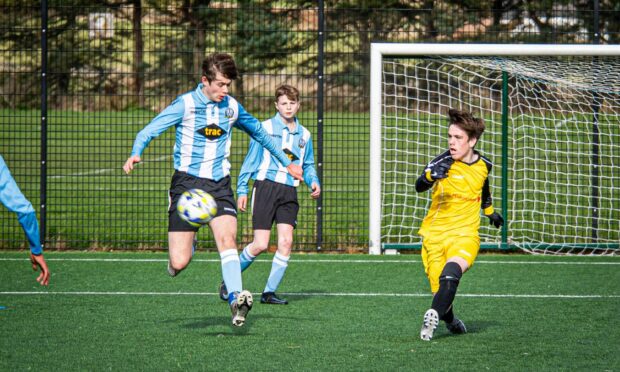 The ADJFA 16s game between Westdyke Thistle (Blue) and Cove United (Yellow) at Lawsondale. Ashton Young has a shot at goal. Image:  Wullie Marr / DC Thomson