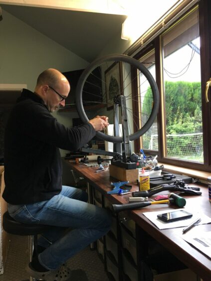 Wheelsmith owner Derek McLay repairing bike wheel.