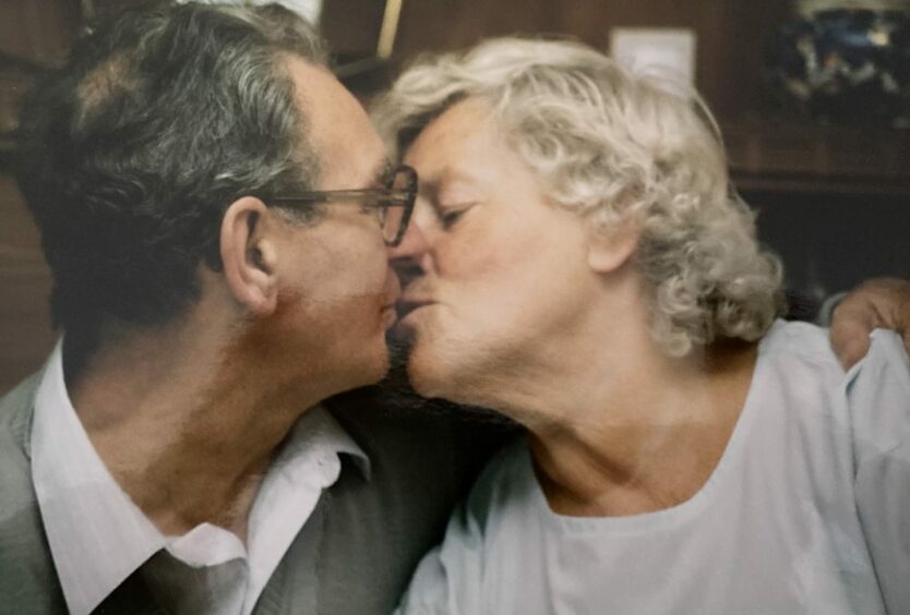 Ilse Collinson and husband Bill kissing.