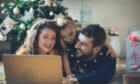 Family planning their Christmas events in Aberdeenshire in front of a Christmas tree.