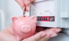 Woman puts coin in piggy bank near an energy meter