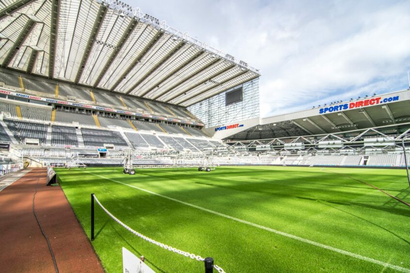 The pitch and stands of St James' Park in Newcastle with the Sports Direct branding. 