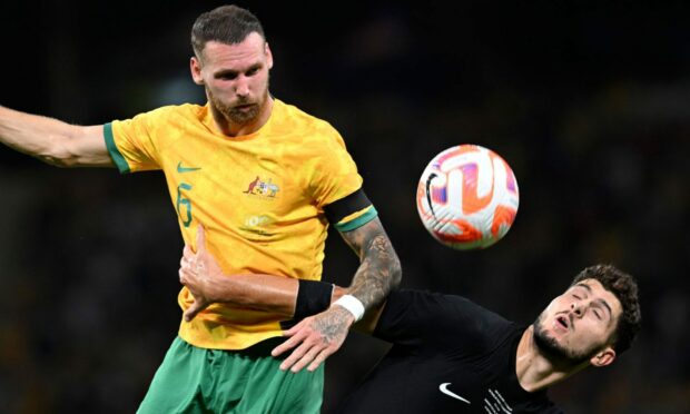 Australia's Martin Boyle, left, and New Zealand's Liberato Cacace compete for a high ball during a friendly. Image: Shutterstock.
