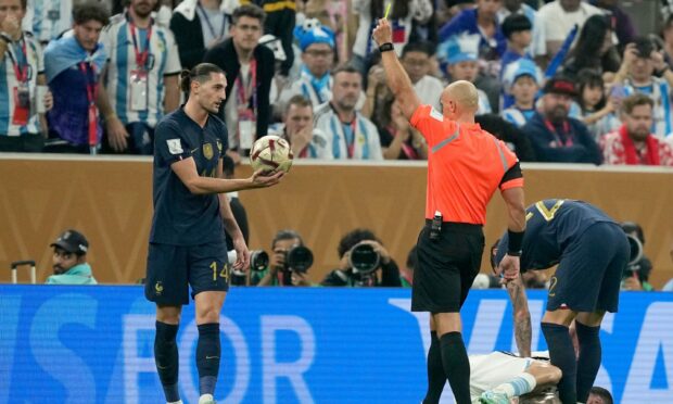 Referee Szymon Marciniak shows a yellow card to France's Adrien Rabiot during the World Cup final.  Image: Shutterstock.