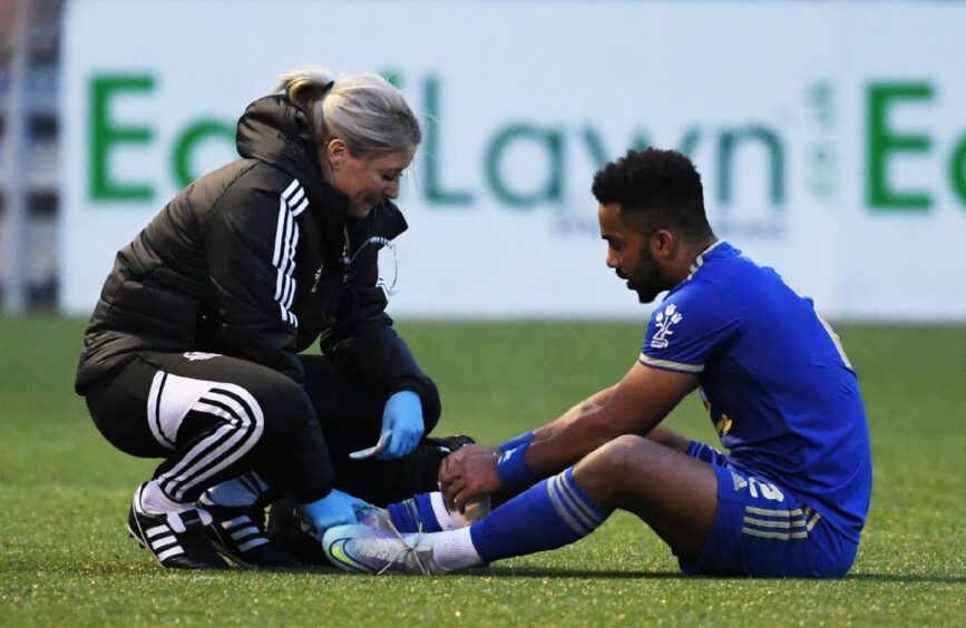 Cove Rangers defender Shay Logan is treated on the pitch. Image: SNS