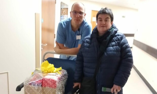Former patient Sarah MacDougall returned to Raigmore Hospital to hand over a gift to consultant John Smith and staff who cared for her when she had Covid. Image: Sarah MacDougall.