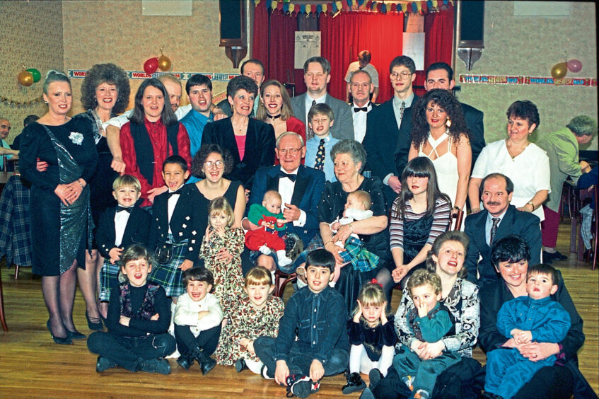 A group of people of all ages smiling for the camera during a golden wedding anniversary