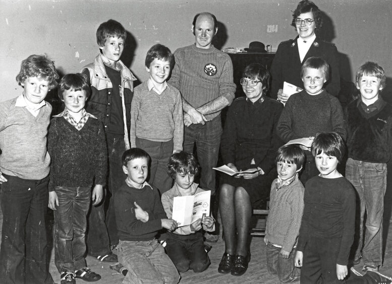 A group of boys smiling at the camera along with a man and woman volunteers