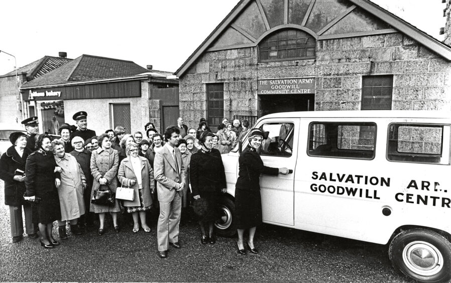 A crowd of people gathered around the Salvation Army Aberdeen community centre and a Salvation Army van