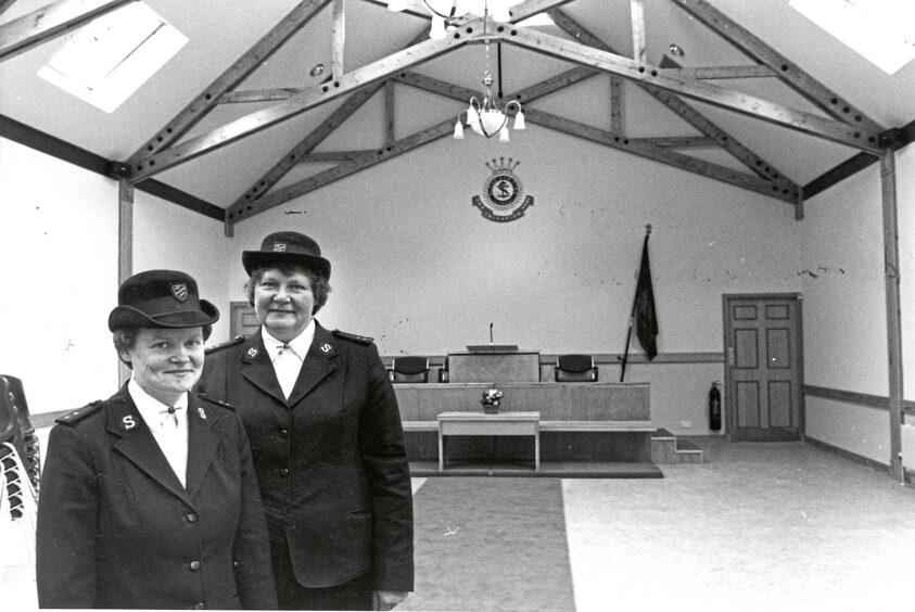 Two women in uniforms inside a goodwill centre