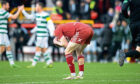 An Aberdeen player holding his head in his hands during the Aberdeen v Celtic match
