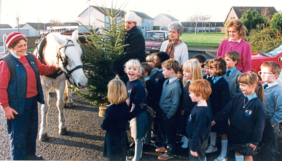 1991 - Delighted Balgownie Primary School pupils with teachers Mrs Ann Wilson and Miss Janice Watt turn out to welcome Mrs Mary Gillan and Kate as they make another Christmas tree delivery.