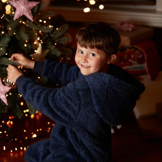 AberNecessities child in front of Christmas tree