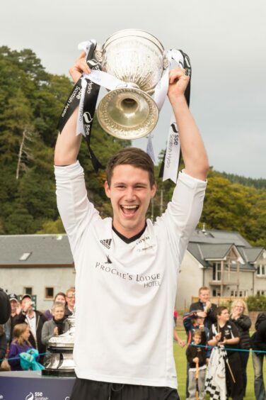 Lovat captain Daniel Grieve lifts the 2015 Camanachd Cup. Image: Neil G Paterson.