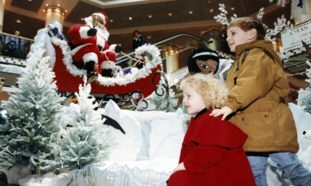 1992: Santa Claus has wasted no time in coming to town and helping Claire Rattray (2), of Bridge of Don, and her brother, Kevin (4), sample the wonders of the festive season during the first Sunday of Christmas shopping at Aberdeen's Bon Accord Centre.