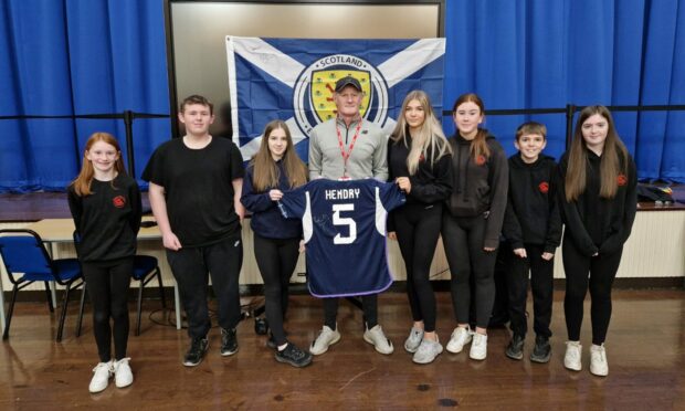 Colin Hendry pictured with Highlife Highland young leaders in Thurso holding Colin Hendry's famous number five shirt. They are from left: Ava Steven, Liam Mackinnon, Nyah McAdie, Colin Hendry, Keira Gunn, Ami Alexander, Connor Gunn and Cadie Cannop.