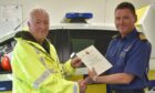 Donald Grant receives long service award from Divisional Commander Matt MacKay after more than 50 years with Gairloch Coastguard Rescue Team.