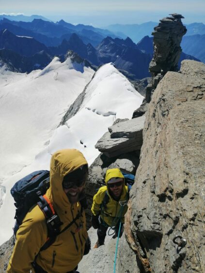 Reaching a summit during their climb in the Alps. 