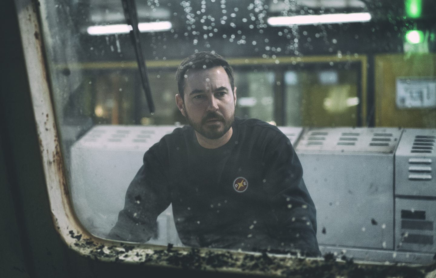 Martin Compston's character Fulmer Hamilton stares out of a window in a still from The Rig. 