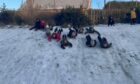 Newton Park pupils slide down a snowy hill