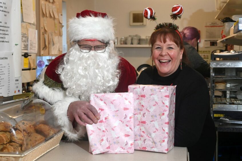 Michelle Clark meets Santa to discuss the presents at the shop.