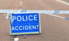 A sign reading "police accident" with a line of police tape sectioning off the road