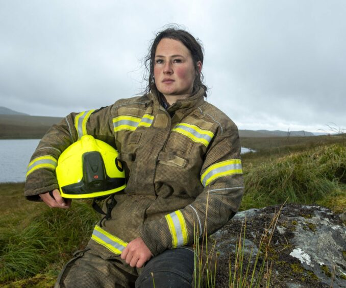 Gamekeeping lecturer Sophie Clarke sitting with her firefighter unfirm on