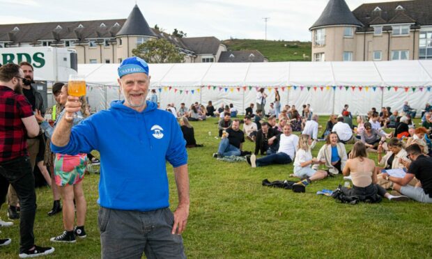 A man holding a beer at the midsummer beer happening in stonehaven