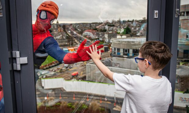 Fraserburgh youngster Jamie Gibb, 8, meets one his heroes during a surprise visit to Royal Aberdeen Children's Hospital. Superheroes abseiled down the building.