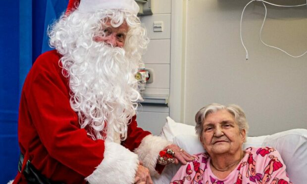 Sir Jimmy Milne dressed as Santa visits Sheena Matthews at Aberdeen Royal Infirmary. Image: Wullie Marr / DC Thomson.