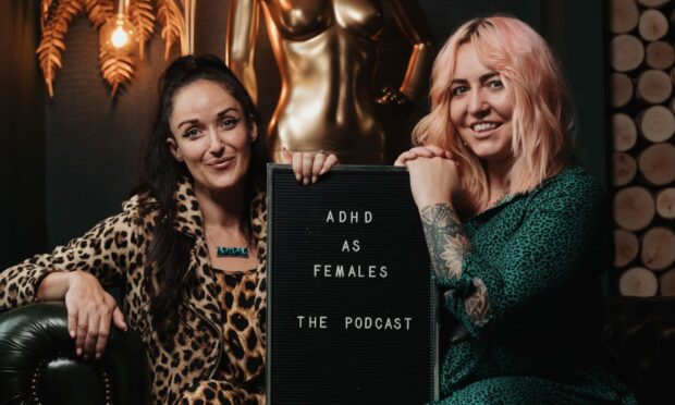 Laura Mears-Reynolds and Dawn Farmer holding a plaque that says 'ADHD AS FEMALES THE PODCAST'