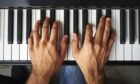 Male pianist's hands playing keys on a piano
