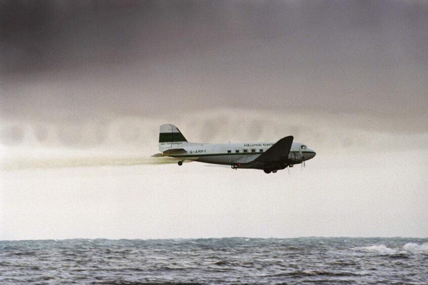 An airplane spraying dispersants on the sea.