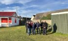 Lossiemouth men standing by shed they'll use for the men's shed group when it's up and running
