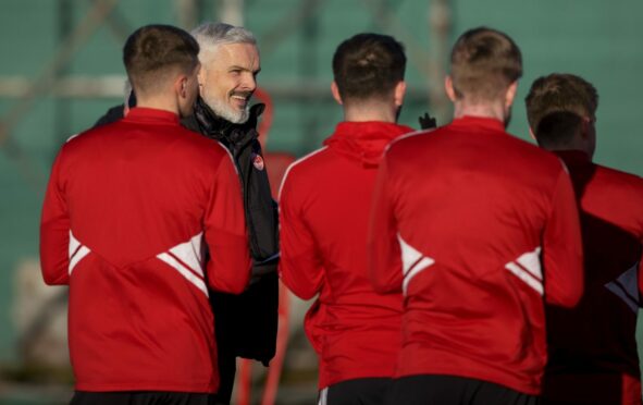 Aberdeen manager Jim Goodwin speaks to his squad during a training session at Cormack Park. Image: SNS.