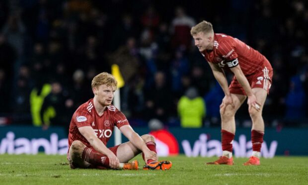 Aberdeen's Liam Scales (left) and Ross McCrorie look dejected at full-time after losing to Rangers in the League Cup semi-final. Image: SNS