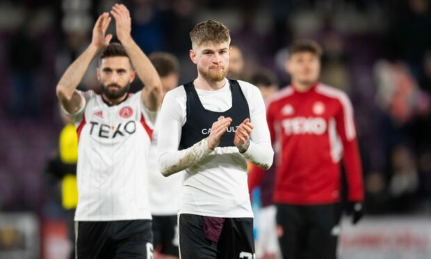 Aberdeen's Hayden Coulson looks dejected at full time at Tynecastle as Graeme Shinnie applauds the travelling support.  Image: SNS.