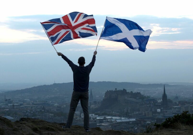 The Saltire and Union Jack flags are raised on Arthur's Seat with a view of Edinburgh Castle ahead of the Scottish Referendum