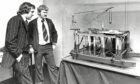 Two men looking at a model of an oil centre on a table